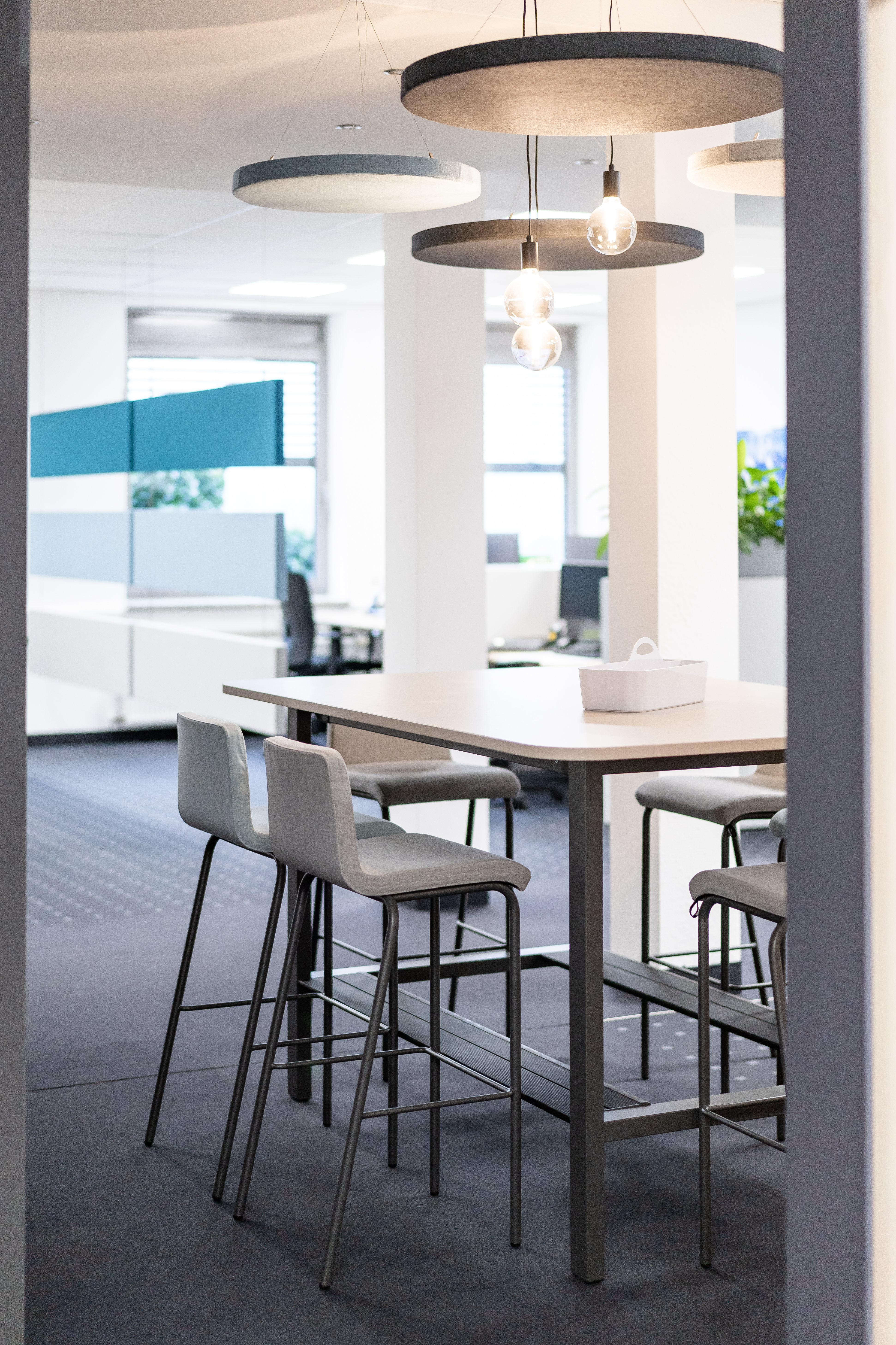 Bartischlösung in einer offenen Bürostruktur mit dekorativen, akustisch wirksamen Deckenabsorber