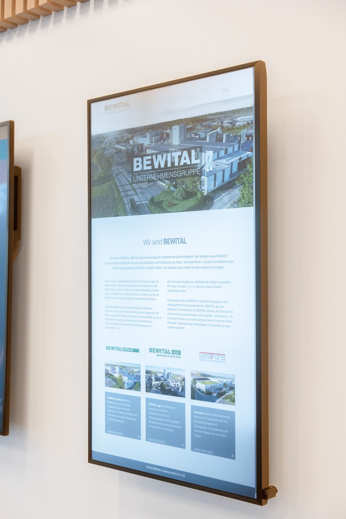 Die repräsentative Wartezone im Eingangsbereich beeindruckt Besucher:innen mit einer integrierten Videowand